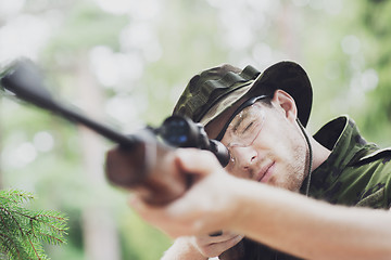 Image showing young soldier or hunter with gun in forest