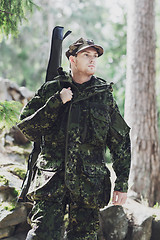 Image showing young soldier or hunter with gun in forest