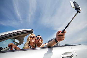 Image showing happy couple in car taking selfie with smartphone