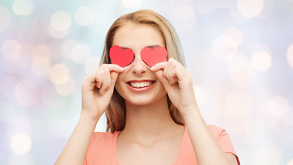 Image showing happy young woman with red heart shapes on eyes