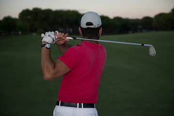 Image showing golfer hitting a sand bunker shot on sunset