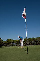 Image showing golf player hitting shot at sunny day