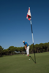 Image showing golf player hitting shot at sunny day