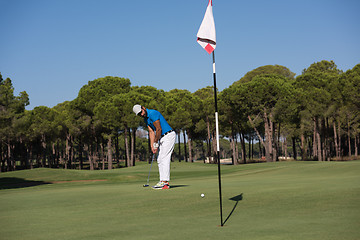 Image showing golf player hitting shot at sunny day