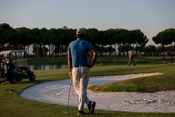 Image showing golfer from back at course looking to hole in distance