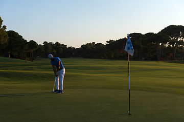 Image showing golfer hitting ball to hole