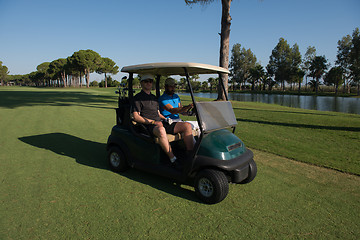 Image showing golf players driving cart at course