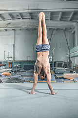 Image showing caucasian man gymnastic acrobatics equilibrium posture at gym background