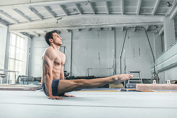 Image showing caucasian man gymnastic acrobatics equilibrium posture at gym background