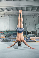 Image showing caucasian man gymnastic acrobatics equilibrium posture at gym background