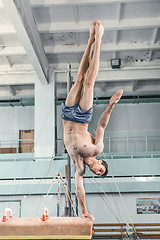 Image showing The sportsman during difficult exercise, sports gymnastics