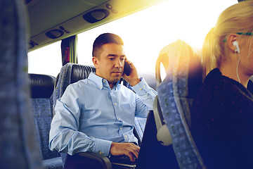 Image showing man with smartphone and laptop in travel bus