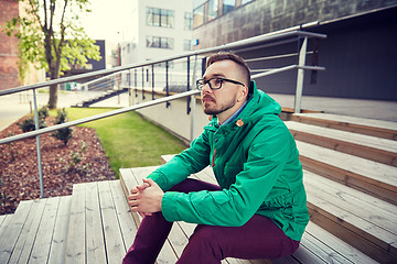 Image showing happy young hipster man sitting on stairs in city