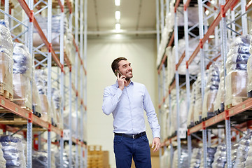 Image showing happy man calling on smartphone at warehouse