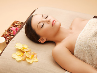 Image showing woman in spa salon lying on the massage desk