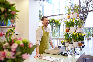 Image showing florist man with clipboard at flower shop counter