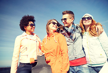 Image showing happy teenage friends in shades talking on street