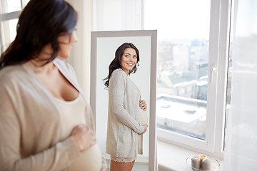 Image showing happy pregnant woman looking to mirror at home