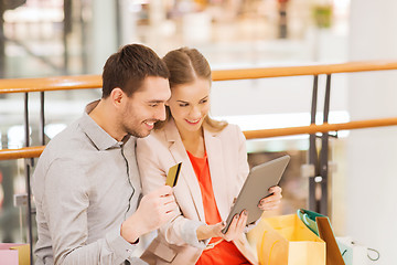 Image showing couple with tablet pc and shopping bags in mall