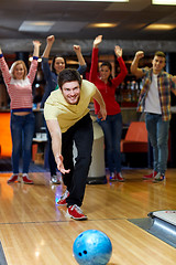 Image showing happy young man throwing ball in bowling club