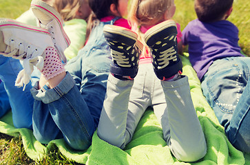 Image showing close up of kids lying on picnic blanket outdoors