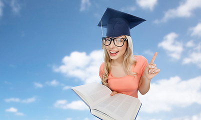 Image showing student woman in mortarboard with encyclopedia