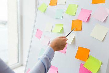 Image showing close up of hand pointing to sticker on flip chart