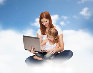 Image showing happy mother with adorable little girl and laptop