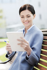 Image showing businesswoman reading notes in notepad outdoors