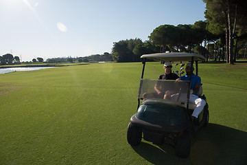 Image showing golf players driving cart at course