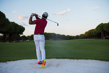 Image showing golfer hitting a sand bunker shot on sunset