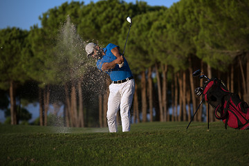 Image showing golfer hitting a sand bunker shot on sunset