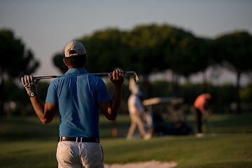 Image showing golfer from back at course looking to hole in distance