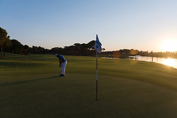 Image showing golfer hitting ball to hole