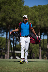 Image showing golf player walking and carrying bag