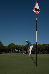 Image showing golf player hitting shot at sunny day