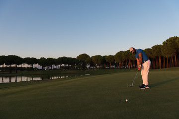 Image showing golfer  hitting shot at golf course