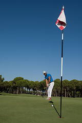 Image showing golf player hitting shot at sunny day