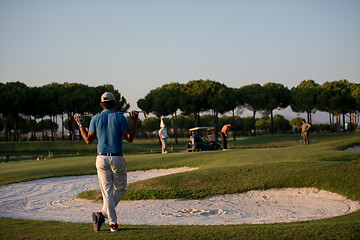 Image showing golfer from back at course looking to hole in distance