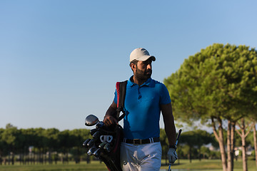 Image showing golfer  walking and carrying bag