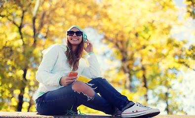 Image showing happy young woman with smartphone and headphones