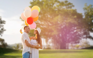 Image showing smiling couple with air balloons outdoors