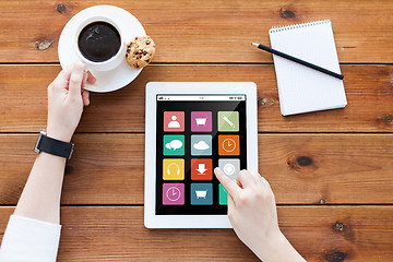 Image showing close up of woman with tablet pc on wooden table