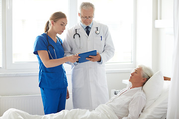 Image showing doctor and nurse visiting senior woman at hospital