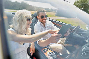 Image showing happy couple with tablet pc in cabriolet car