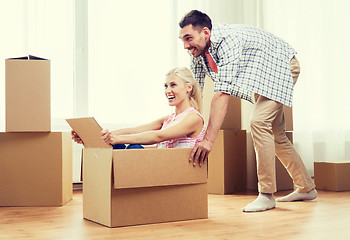 Image showing couple with cardboard boxes having fun at new home