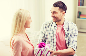 Image showing happy man giving woman gift box at home