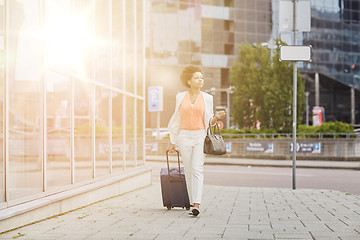 Image showing young african woman with travel bag in city