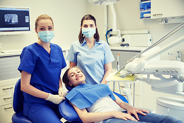 Image showing happy female dentist with patient girl at clinic