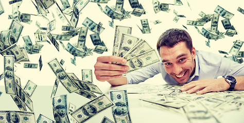 Image showing happy businessman with heap of money